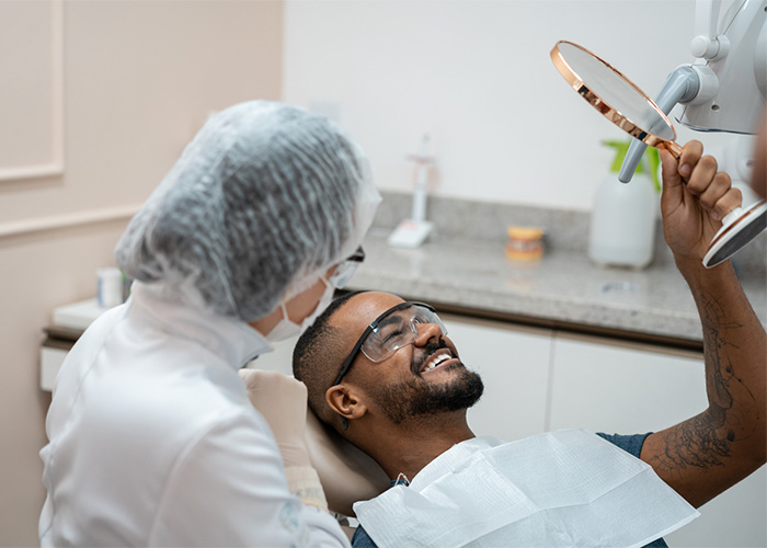 A patient examines his teeth after dental work